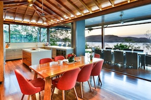 A modern kitchen with a wooden countertop and red chairs.