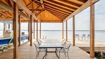 Enjoy a serene waterfront view from this deck with a table and chairs.