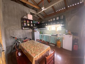 Enjoy meals at the dining table for four, with a fully equipped kitchen featuring a refrigerator, stove, and ample storage.