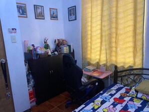 Cozy bedroom with a bed, desk, and chair, offering a comfortable space to work and rest.