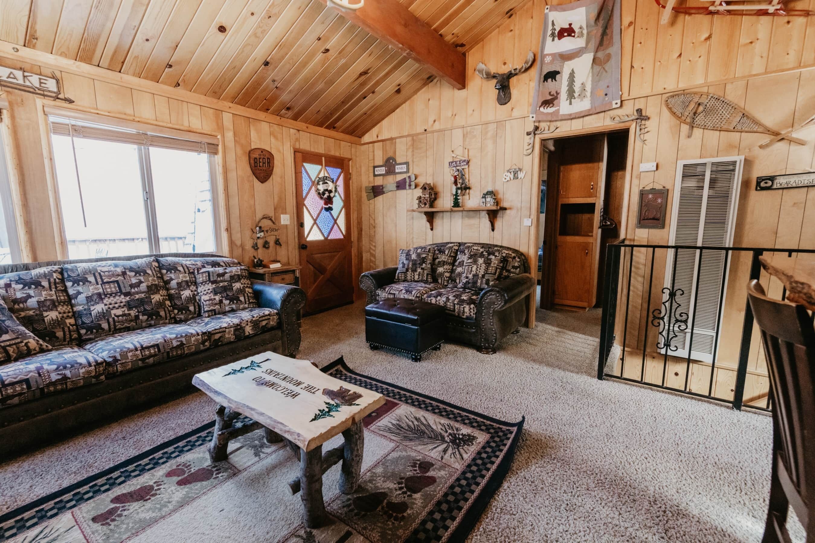 L’intérieur d’un chalet accueillant, avec un canapé, un fauteuil et une table basse.