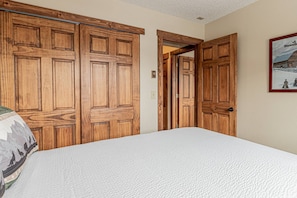 Un dormitorio con una cama grande, armarios de madera y un cuadro enmarcado en la pared.
