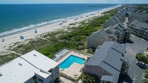 A resort with a pool, beachfront view, and multiple buildings.