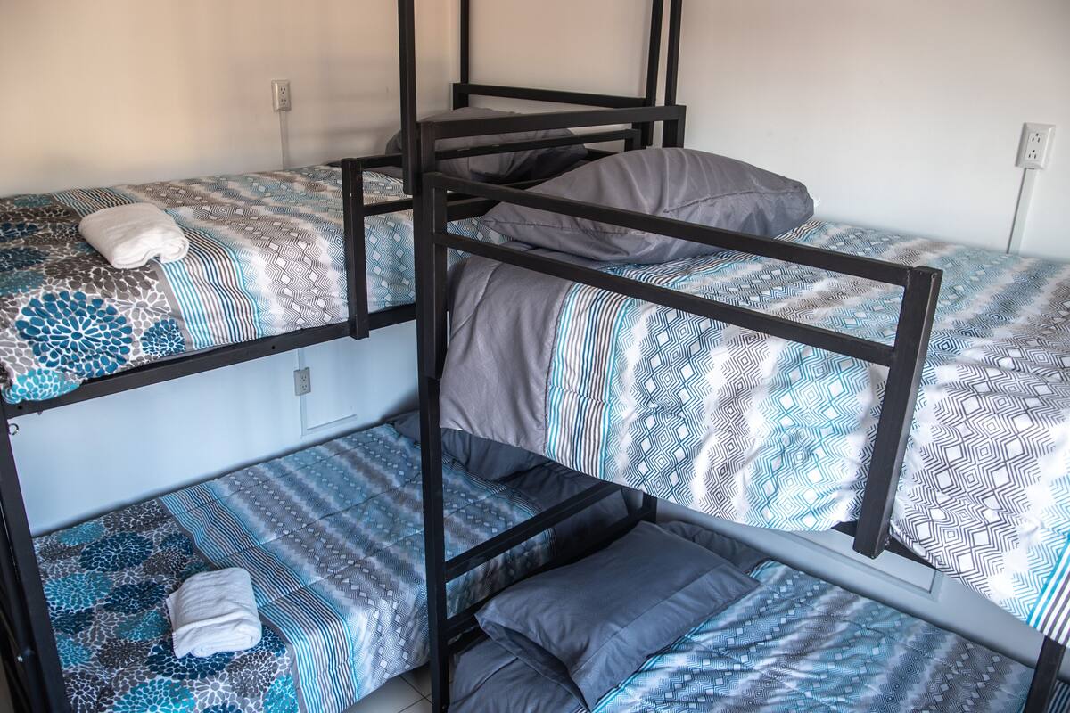 A bunk bed with patterned bedding and a white towel on the lower bunk.
