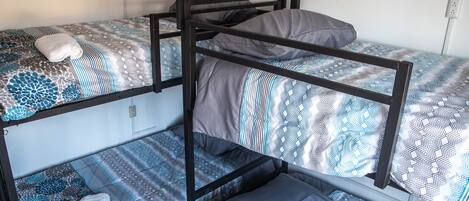 A bunk bed with patterned bedding and a white towel on the lower bunk.