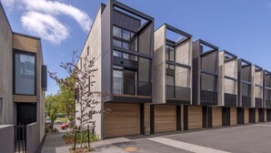 A modern multi-story building with large windows, balconies, and a flat roof. - Latimer View Apartment (Christchurch)
