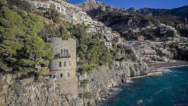 Un borgo costiero con edifici costruiti su scogliere a picco sul mare.