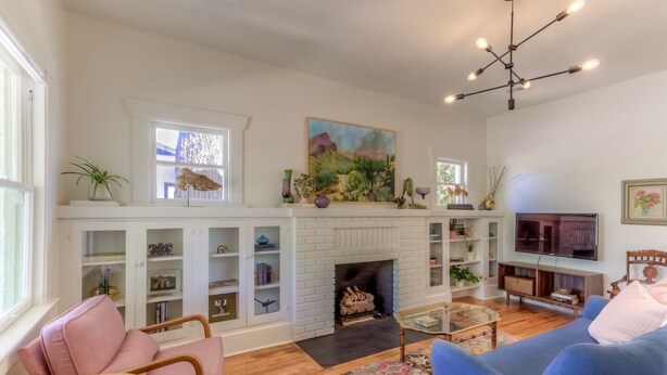 Una sala de estar con chimenea, estanterías, televisor y asientos.