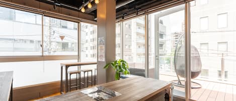 A modern workspace with a wooden table, chairs, and a potted plant.