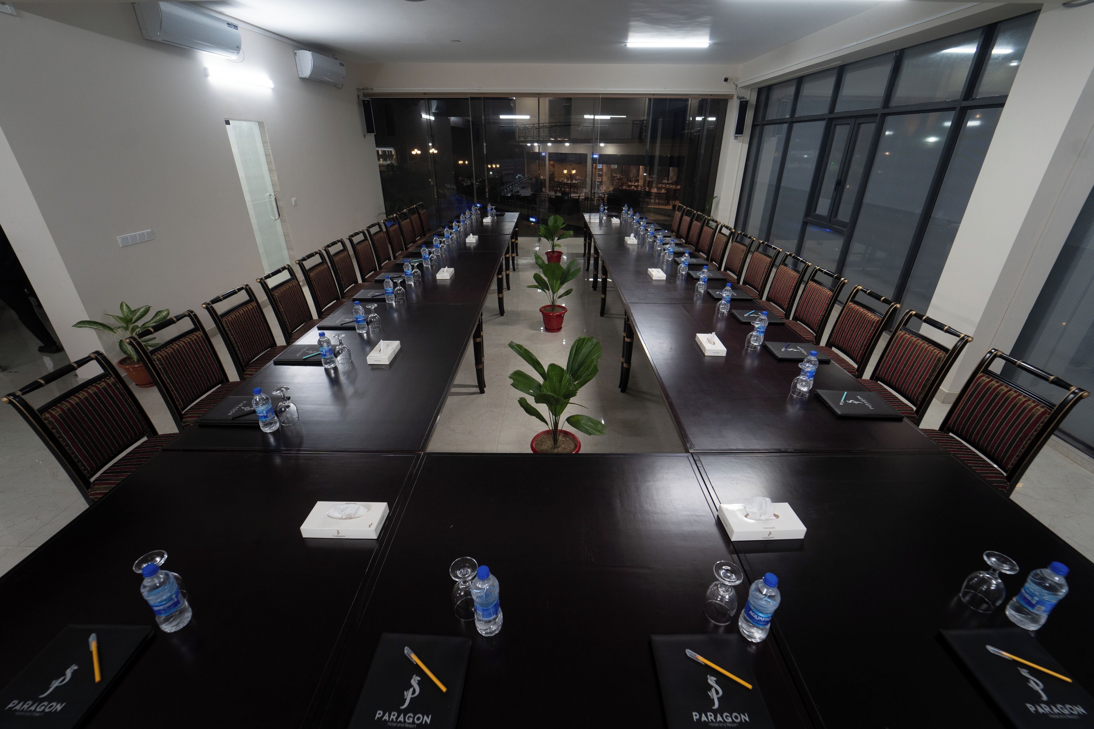 A conference room with a long table, chairs, water bottles, and nameplates.