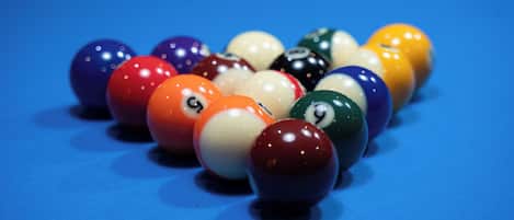 A pool table with various colored billiard balls.