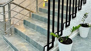 A modern staircase with metal railings and potted plants. - Urban Hotel (Bishkek)