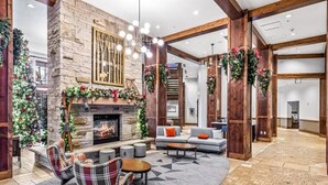 Un hall acogedor con chimenea de piedra, asientos cómodos y decoración festiva.