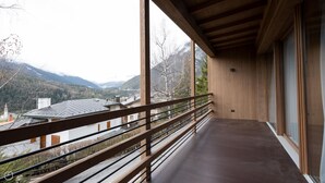 Un balcon avec vue sur les montagnes et une vallée.