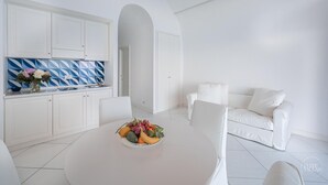 A modern, white-themed living space with a kitchen, dining area, and a white sofa. - Villa Blue Sea Amalfi (Ravello)