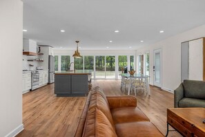 Relax in a spacious living area with a large island, dining table, and comfortable sofa.