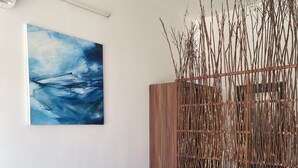 A bedroom with a bed, a painting, and a wooden headboard with branches. - My Hoa Oceanfront Home (Vinh Hai)