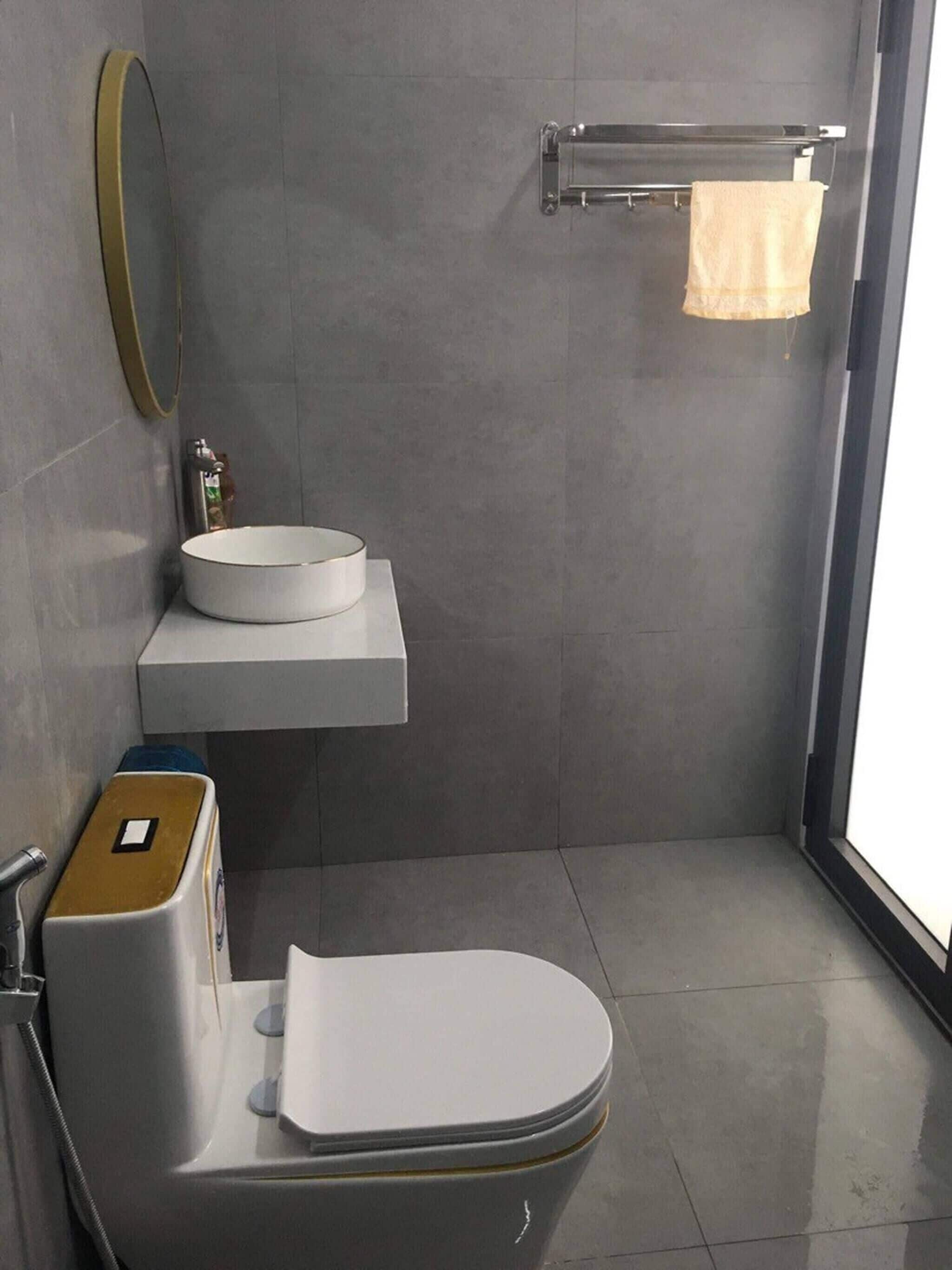 Un baño moderno con inodoro, lavabo y espejo.