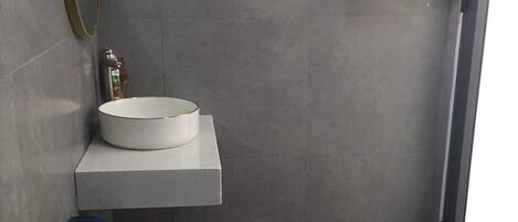 Un baño moderno con inodoro, lavabo y espejo.