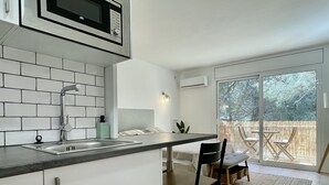 Eine moderne Küche mit eingebauter Mikrowelle, einer Spüle und einem Essbereich mit Tisch und Stühlen.