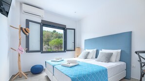 Una camera da letto moderna con un letto grande, vista sull'esterno e un appendiabiti in legno.