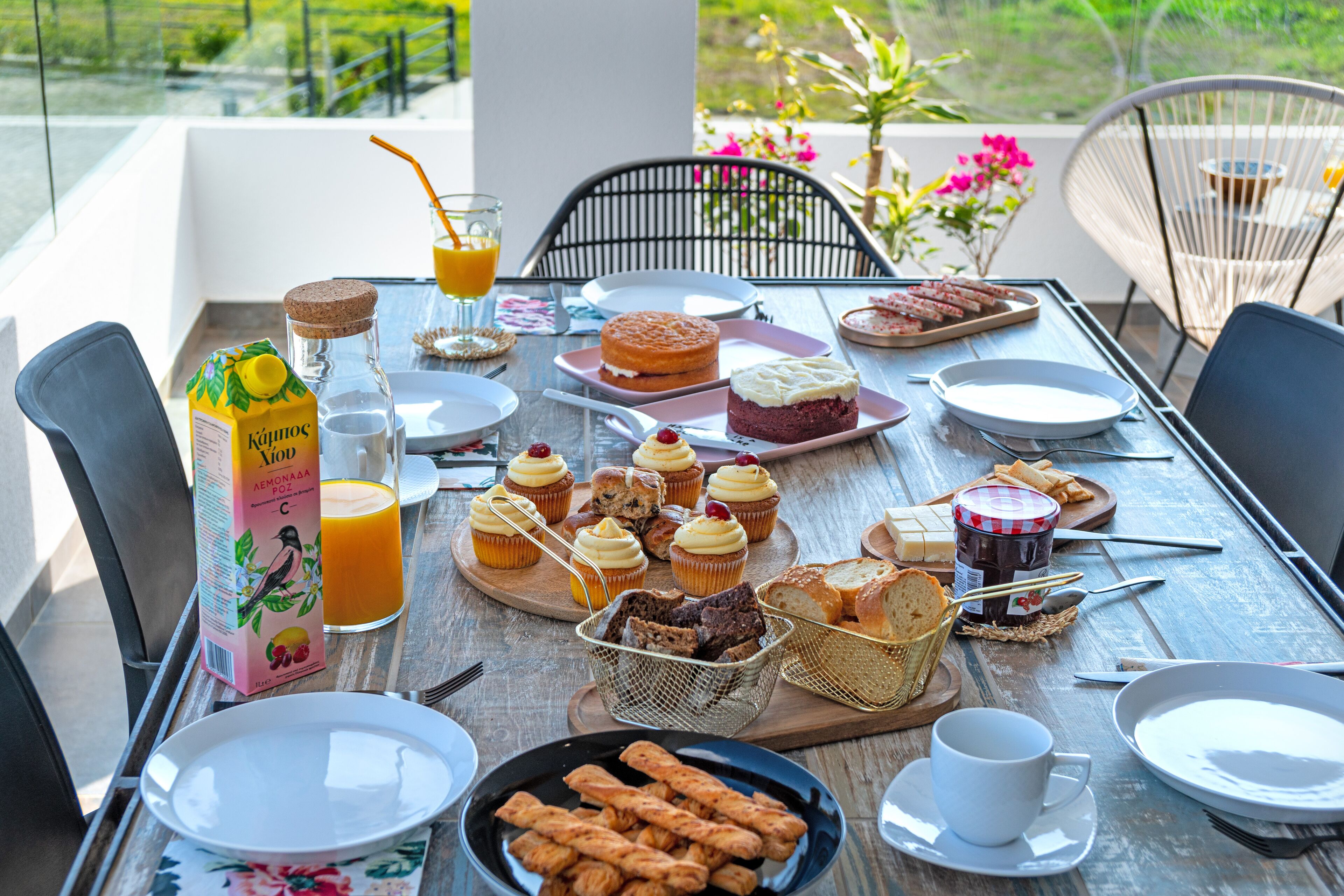 A breakfast table with various pastries, a juice box, and a jar of jam.