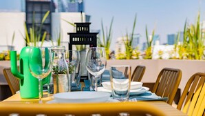 Une table dressée pour le dîner, avec une vue sur la ville en arrière-plan.