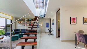 Un intérieur moderne avec un escalier, un coin salon et des œuvres d’art.