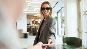 Un intérieur moderne avec un luminaire circulaire, un fauteuil vert et un espace d’accueil.