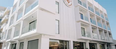 A multi-story hotel with a modern design, featuring balconies and large windows.