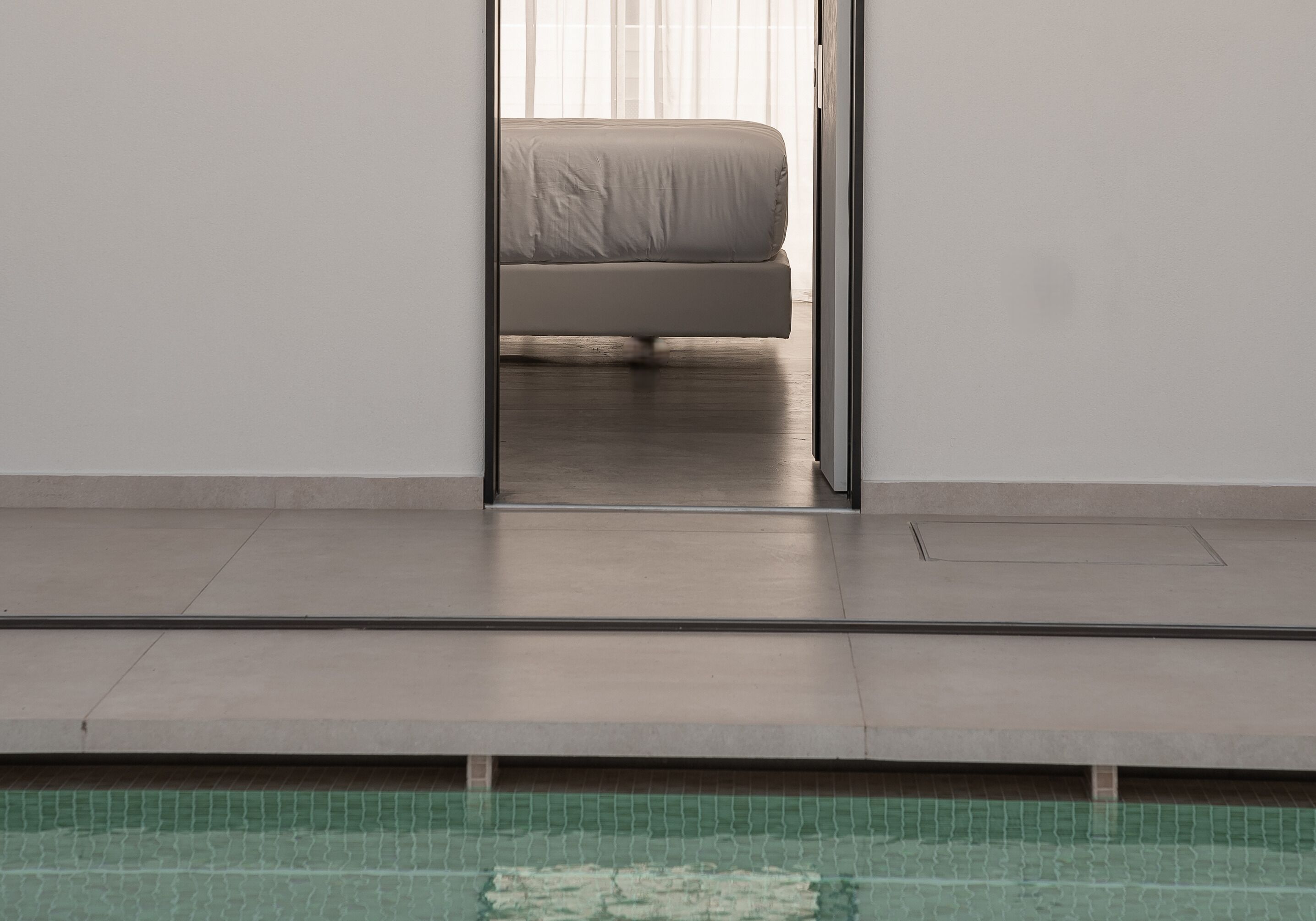 Een moderne badkamer met een douchecabine van glas, een open toilet en een betegelde vloer.