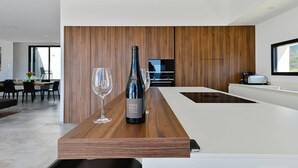 Una cocina moderna con encimera de madera, una botella de vino y una copa.
