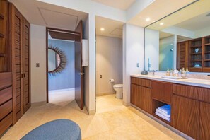 Une salle de bain moderne avec un grand miroir, des meubles en bois et des toilettes.
