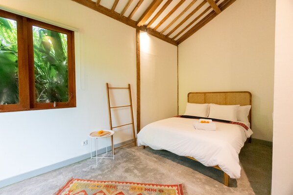 Relax in this serene bedroom with a single bed, bedside table, and window overlooking lush greenery.