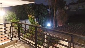 A balcony with a metal railing, a tiled floor, and various potted plants. - Dewi House Pondok Hijau Parongpong Bandung 1 (Parongpong)