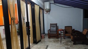 A room with a tiled floor, a ceiling fan, a chair, and a table. - Dewi House Pondok Hijau Parongpong Bandung 1 (Parongpong)