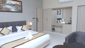 A hotel room with a large bed, a wardrobe, a mirror, and a desk. - Pine Regency - Aravali's Peak view (Udaipur)