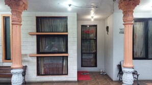 A building entrance with large windows, a red mat, and a door with a sign. - Pondok Seruni Kemanggisan Jakarta (Jakarta)