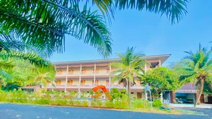 A multi-story hotel with balconies, surrounded by palm trees and greenery. - Chanpailin Omarzaa (Krabi)