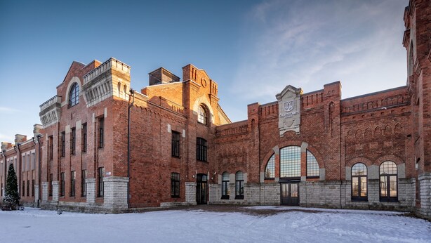 A large brick building with arched windows and a central tower. - Dunten Hotel (Tallinn)