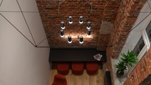 A modern interior with a brick ceiling, wooden floor, and red seating. - Dunten Hotel (Tallinn)
