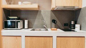 Una cocina moderna con microondas, pileta y cafetera.