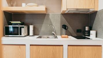 A modern kitchen with a microwave, sink, and coffee maker.