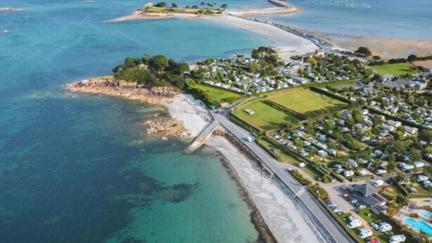 An aerial view of a coastal residential area with a beach, clear waters, and a road leading to a gated community. - Authentic 16th-century Breton house in the heart of downtown, 2 minutes from the beach (Saint-Pol-de-Léon)