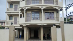 A multi-story residential building with a central entrance, balconies, and a checkered floor pattern. - Magvaris Comfort Inn (Shillong)