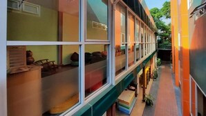 A multi-story building with large windows and a covered walkway. - MRT Thaphra spthaphra (Bangkok)