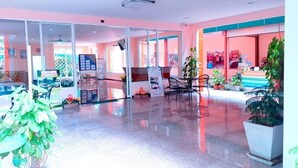 A spacious lobby with a glass partition, seating area, and potted plants. - MRT Thaphra spthaphra (Bangkok)