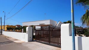 A residential property with a gated entrance, a white wall, and a clear blue sky. - 3243 Villetta Morelli by Barbarhouse (Racale)