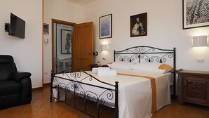 A neatly arranged bedroom with a bed, a chair, and a wooden cabinet. - 3243 Villetta Morelli by Barbarhouse (Racale)
