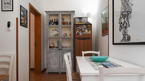A dining area with a white table and chairs, a teal bowl, and a refrigerator with photos and magnets. - 3243 Villetta Morelli by Barbarhouse (Racale)